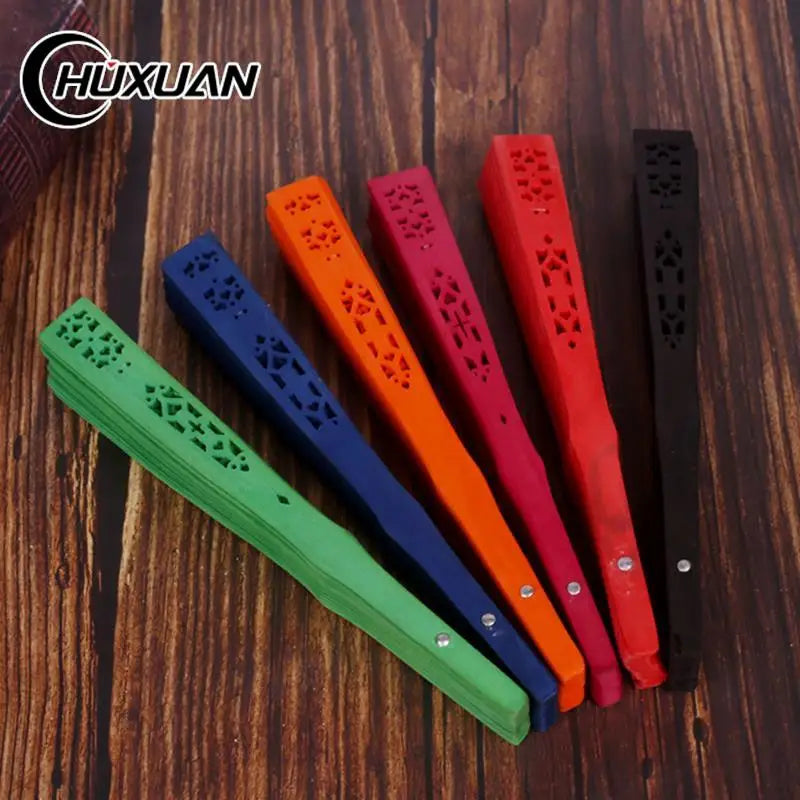A collection of hand carved bamboo folding fans in various colors including green, blue, orange, and red.