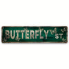 A distressed green metal tin sign with the words BUTTERFLY ST carved into it and decorated with butterflies.
