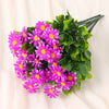 A bouquet of vibrant purple and pink silk daisies with green foliage.