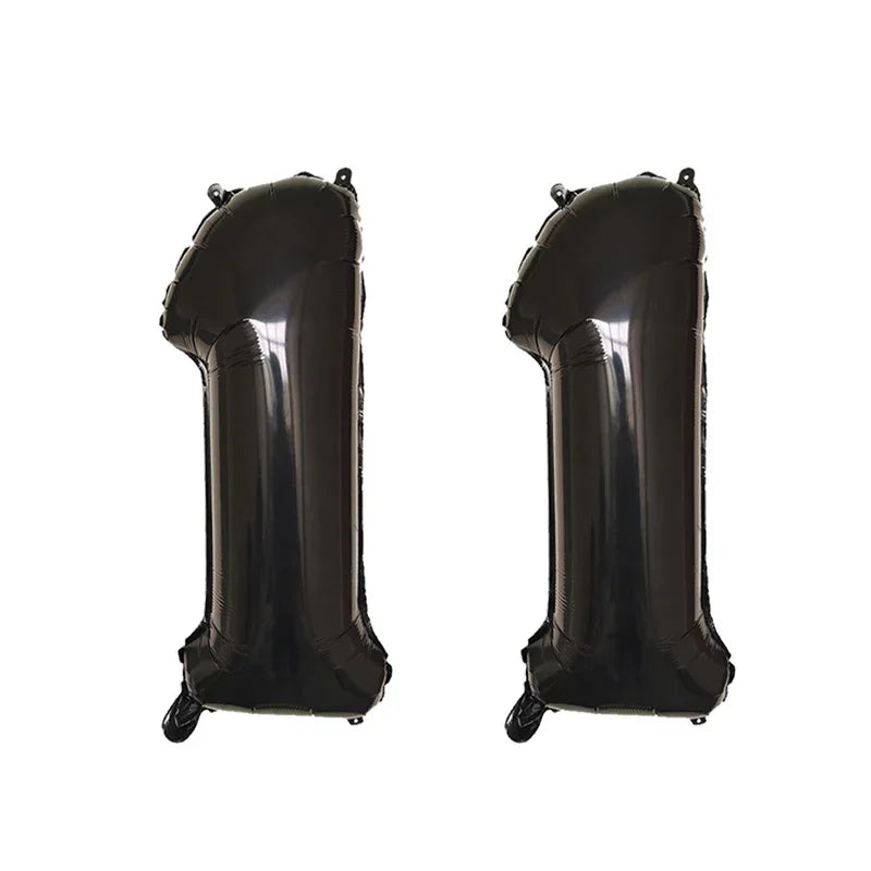 Two black helium foil number balloons shaped like the number 1.