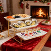Elegant three-tier serving rack displaying seafood appetizers on a wooden table.