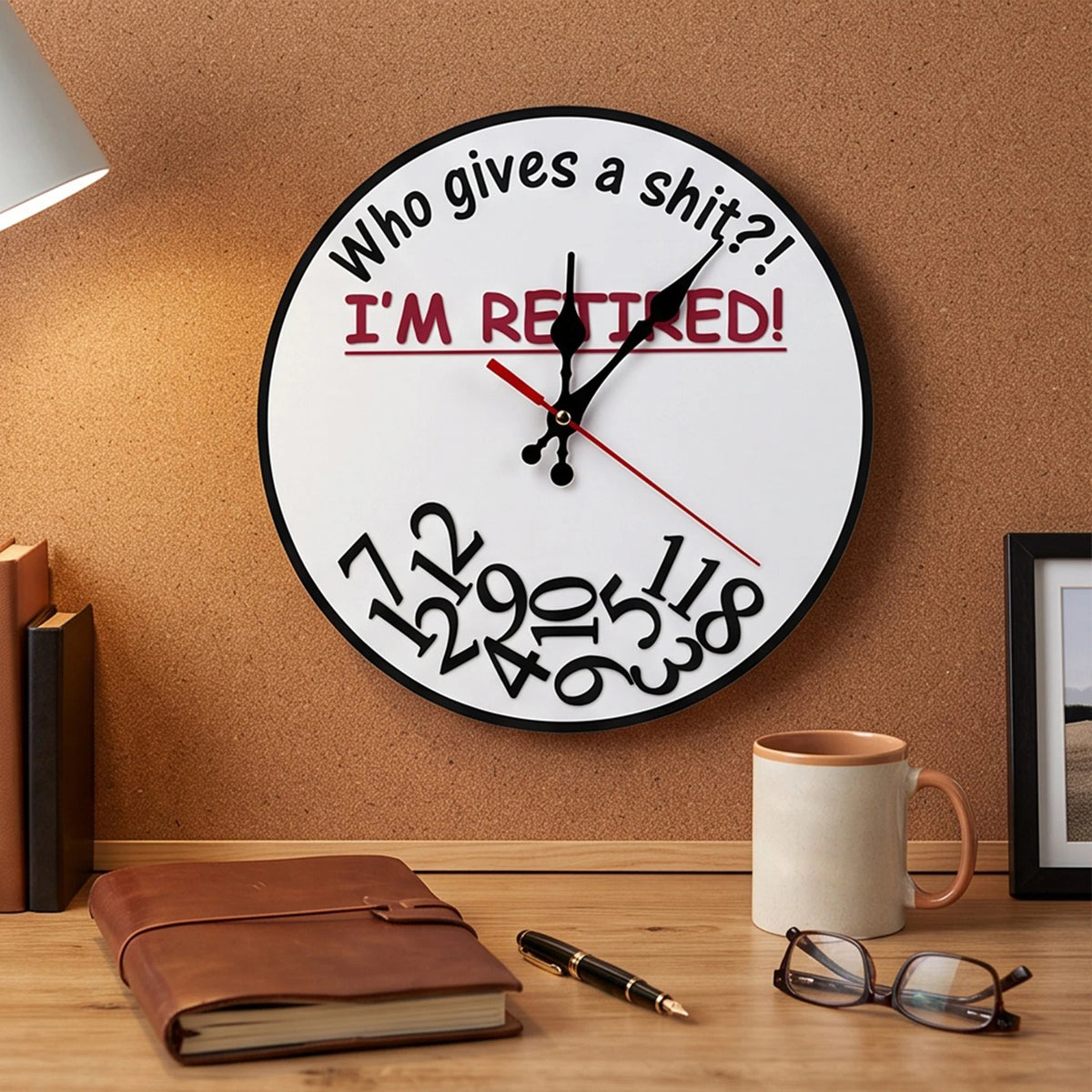 Runde schwarz-weiße Wanduhr mit dem Text „Who gives a shit I'm retired“ mit Ziffern und Zeigern auf Holz