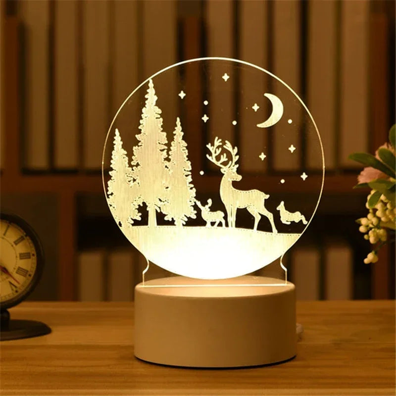 A glowing acrylic night light featuring a silhouette of a deer and trees against a dark background.