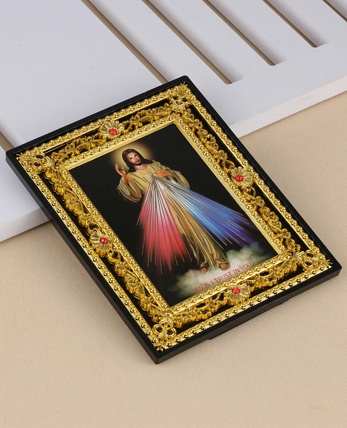 A framed religious icon depicting Jesus in a flowing garment with a radiant aura, set in an ornate gold frame.