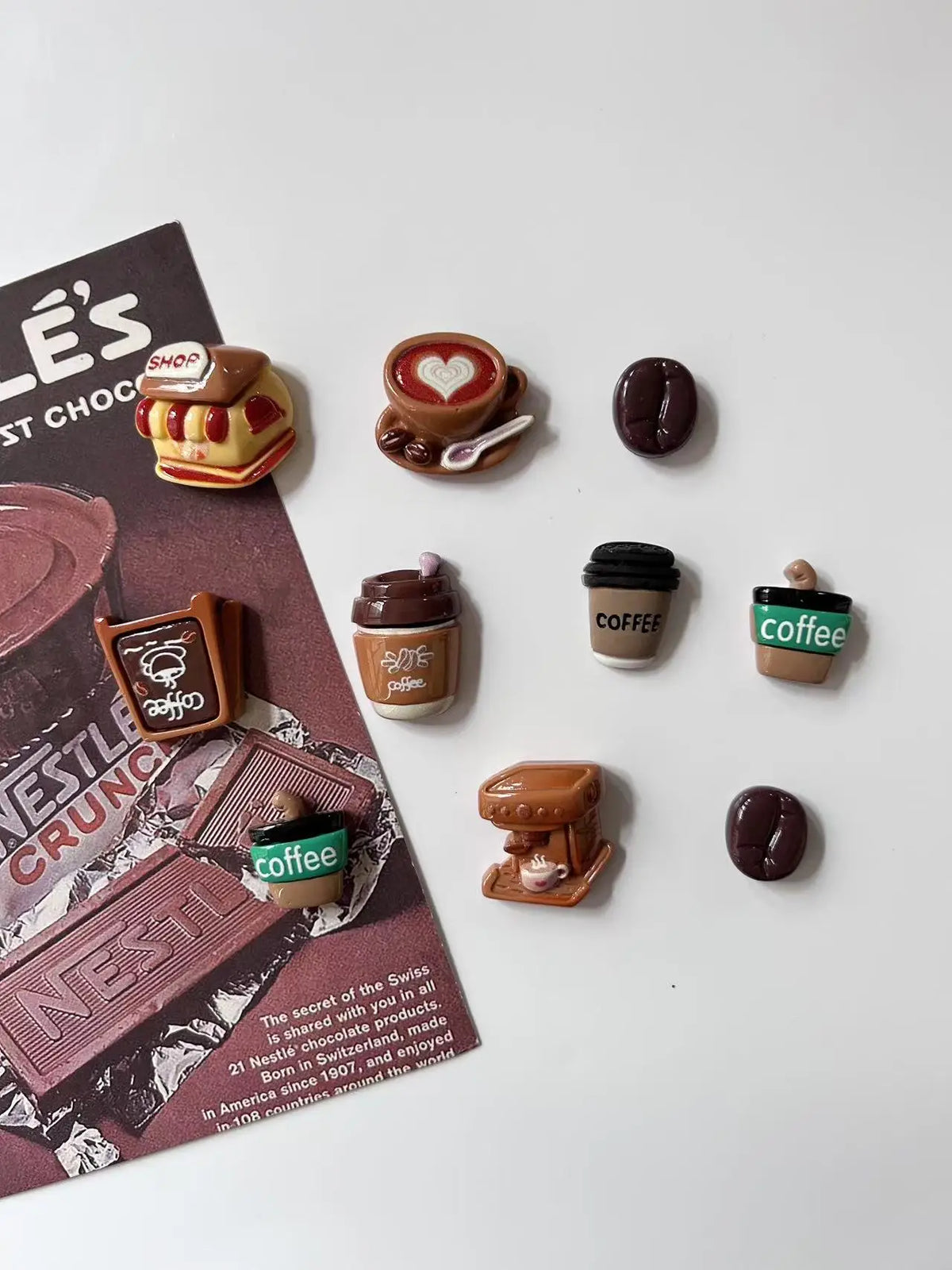 A collection of coffee bean fridge magnets featuring various coffee-themed designs and colors.