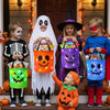 A family of four children and a woman posing with illuminated Halloween trick-or-treat bags.