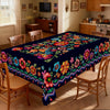 A vibrant Mexican carnival printed tablecloth featuring colorful floral patterns on a dark background.