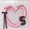 Pink heart-shaped balloon decoration with Happy and Birthday text