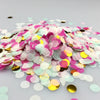 A pile of multicolor paper confetti consisting of pink, yellow, and green pieces.