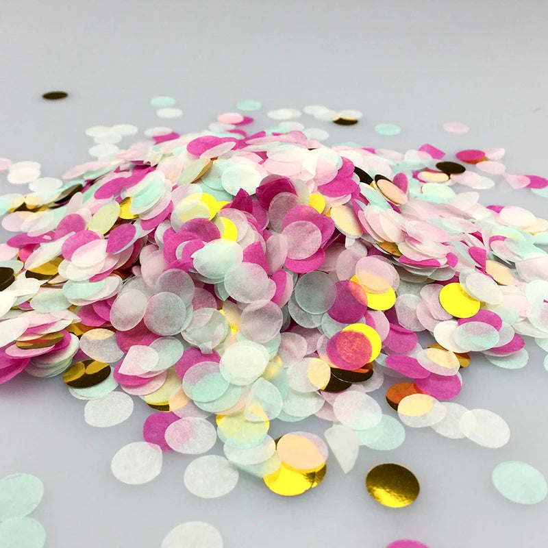A pile of multicolor paper confetti consisting of pink, yellow, and green pieces.