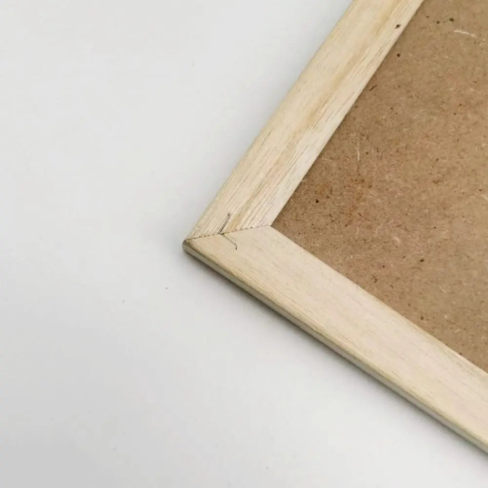 A light wooden frame surrounds a rectangular cork board, ready for custom decor.
