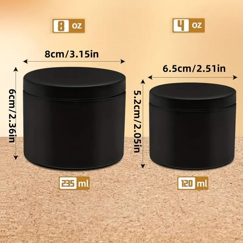 A set of two black metal candle tins with lids, one 8 oz and one 4 oz.