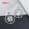 20 pieces of silver vintage ship anchor charms for jewelry making displayed on a dark surface.