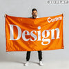 A man holds up an orange flag banner with the word Design printed on it.