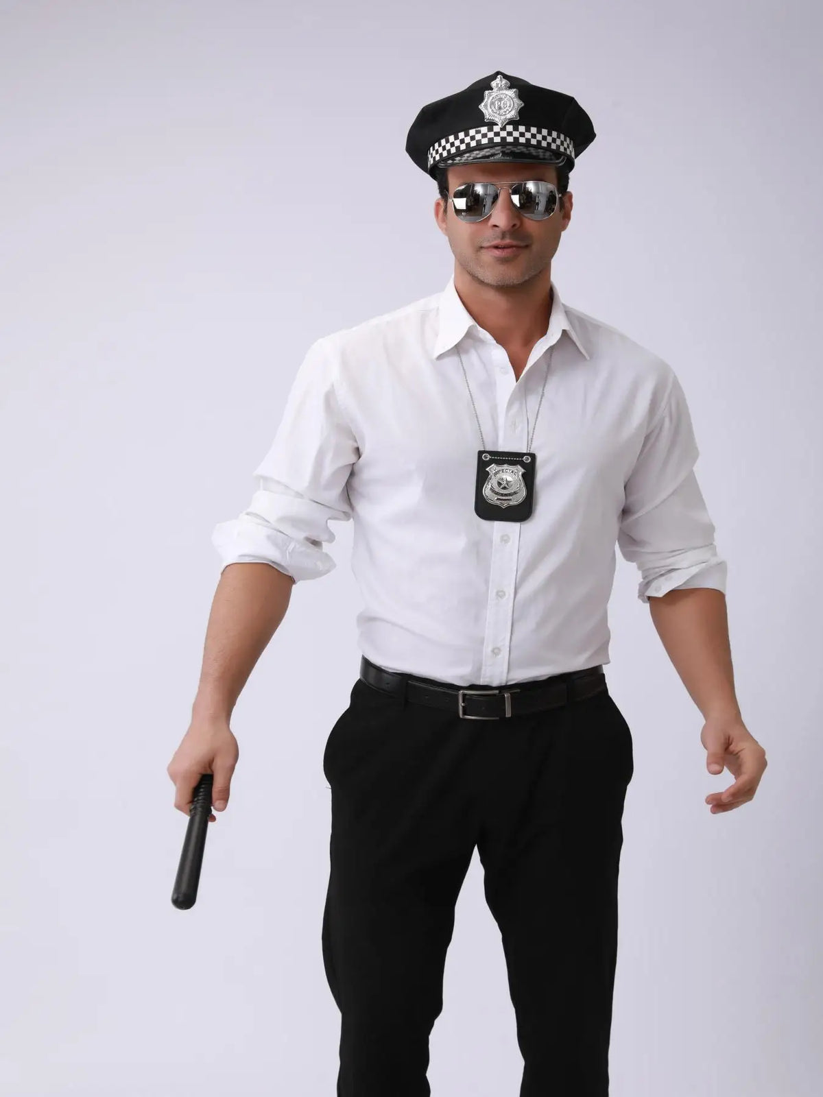 Un hombre con camisa blanca y pantalones negros, gorra de policía y gafas de sol, sostiene un collar con placa realista.