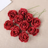 A cluster of twenty deep red foam rose blooms on a beige fabric background.