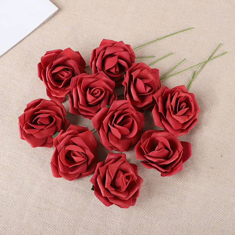 A cluster of twenty deep red foam rose blooms on a beige fabric background.