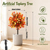 Árbol topiario artificial en maceta cilíndrica con follaje de colores estacionales, exhibido en interiores.