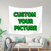 A white tapestry featuring the text Custom Your Picture in green font displayed on a living room wall.
