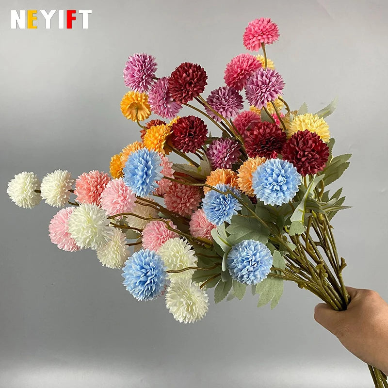 Un ramo de flores artificiales de crisantemo y diente de león en tonos rosa, rojo, amarillo y azul.