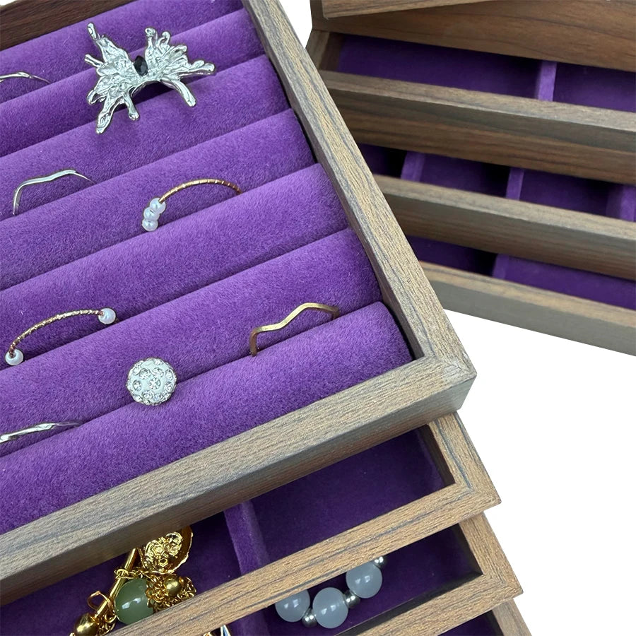 Boîte en bois pour bijoux avec doublures de velours violet affichant des bijoux en argent et or.
