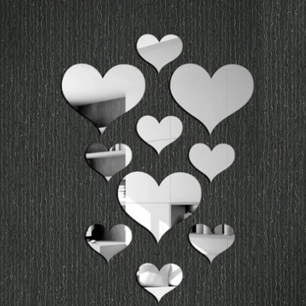 A collection of white 3D acrylic heart mirror wall stickers scattered against a dark background.