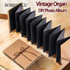 Ein Set aus schwarzen Vintage-Orgel-DIY-Albumseiten und ein Raufaser-Fotobuch auf einer Holzoberfläche.
