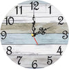 A round wooden wall clock showing the time as approximately 12:30, with a dark pendulum and white face.