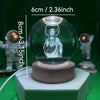 A clear glass crystal ball night light featuring a depiction of Jesus Christ on a wooden base.
