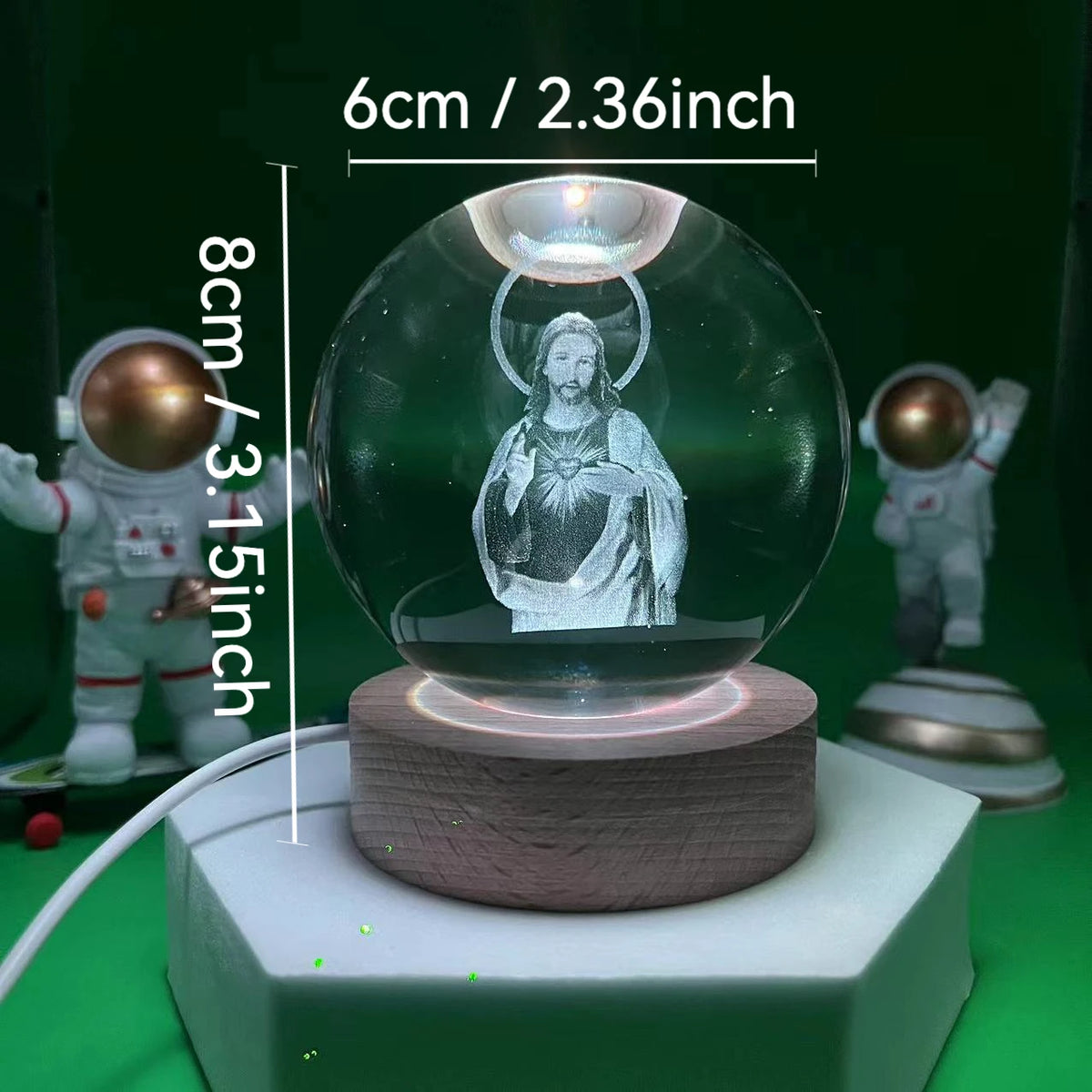 A clear glass crystal ball night light featuring a depiction of Jesus Christ on a wooden base.