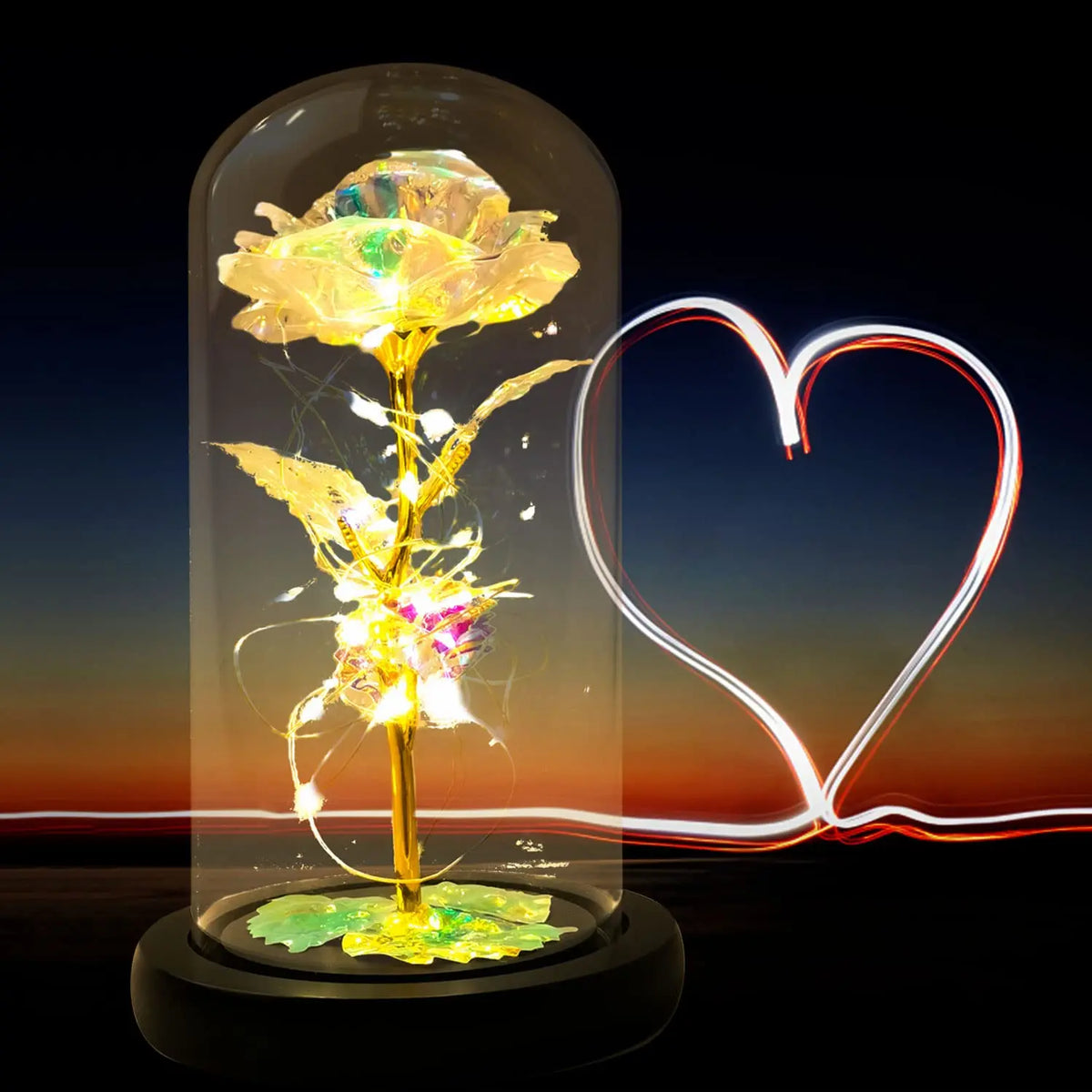 Une rose de verre éternelle avec une lumière LED est présentée dans un récipient cylindrique transparent sur fond sombre.