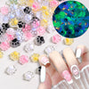 A hand displays various pink and white 3D resin ladybug nail art charms on fingernails and a circular background.