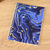 A spiral-bound notebook featuring a marbled blue and gold design for sticker collecting.