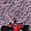 A red Formula 1 racing car model is displayed against a blurred background of pink and white spots.