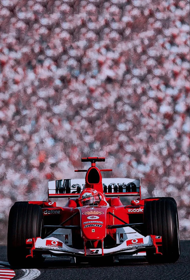 A red Formula 1 racing car model is displayed against a blurred background of pink and white spots.