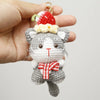 Handcrafted crochet cat keychain pendant with a red and white knitted hat and bow