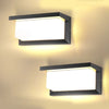 A modern black rectangular LED wall sconce with a bright white light mounted on a beige wall.