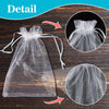 Detail shot of an elegant white organza drawstring gift bag and a circular mesh bag on a wooden surface.
