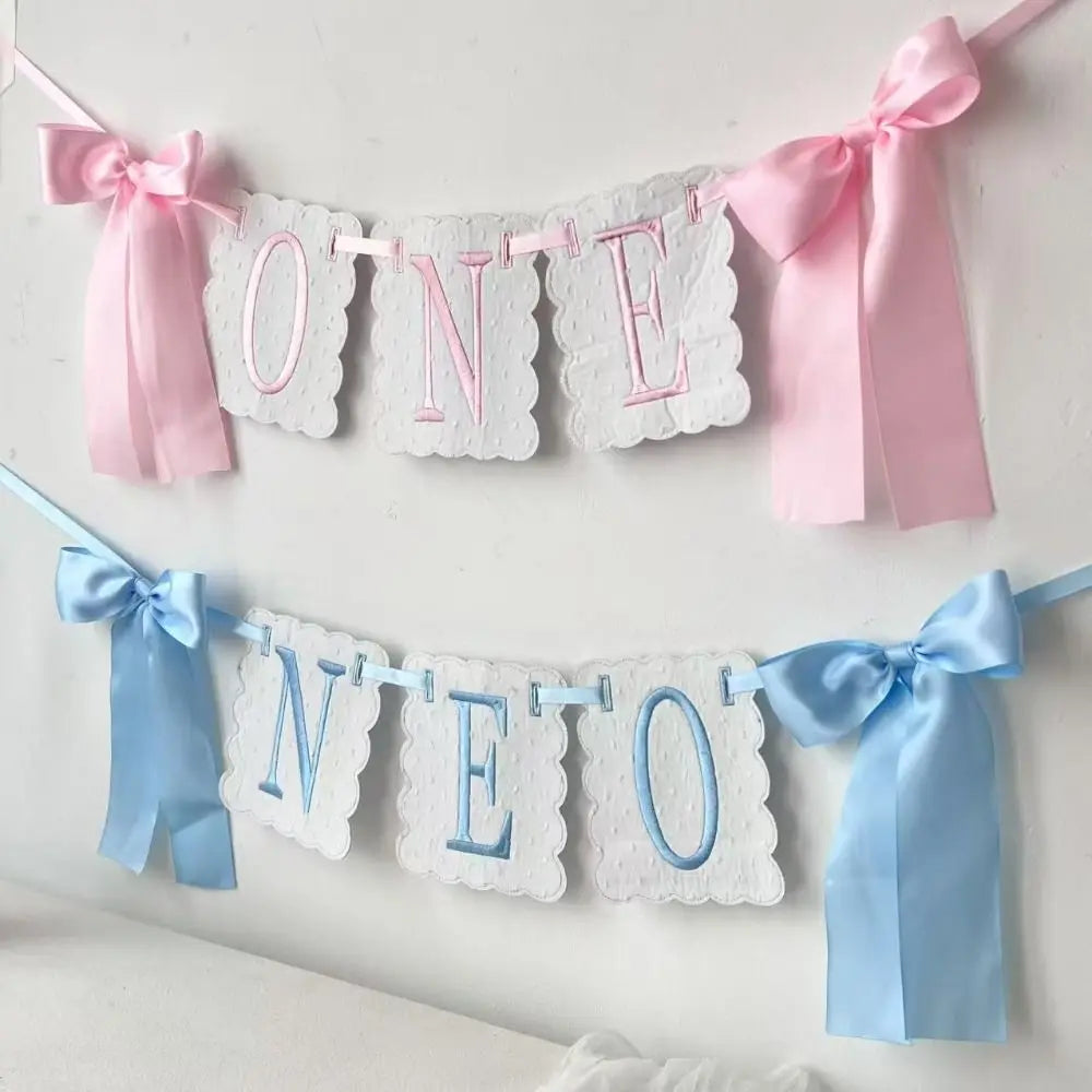 Pink and blue decorative birthday garland spelling out ONE and NEO made of lace