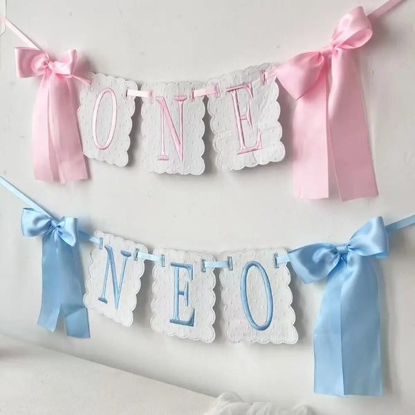 Pink and blue decorative birthday garland spelling out ONE and NEO made of lace