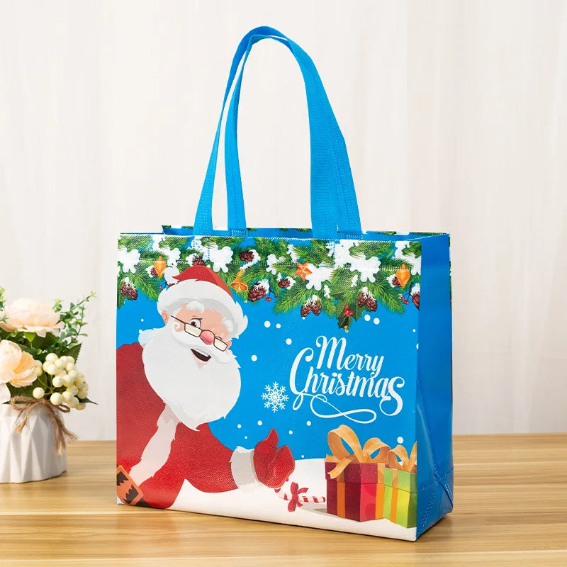 A blue festive tote bag with a Christmas design featuring Santa, greenery, and the text Merry Christmas.