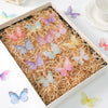 A box filled with various 3D embroidered butterfly patches in shades of pink, purple, and yellow.