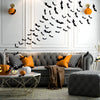 A modern living room decorated with black bat wall stickers on the wall and orange accent pillows.