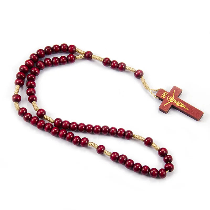 A wooden rosary beads necklace featuring a string of red beads and a small wooden Jesus crucifix.