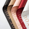 A set of five rolls of waterproof floral wrapping paper in shades of black, beige, pink, and red.