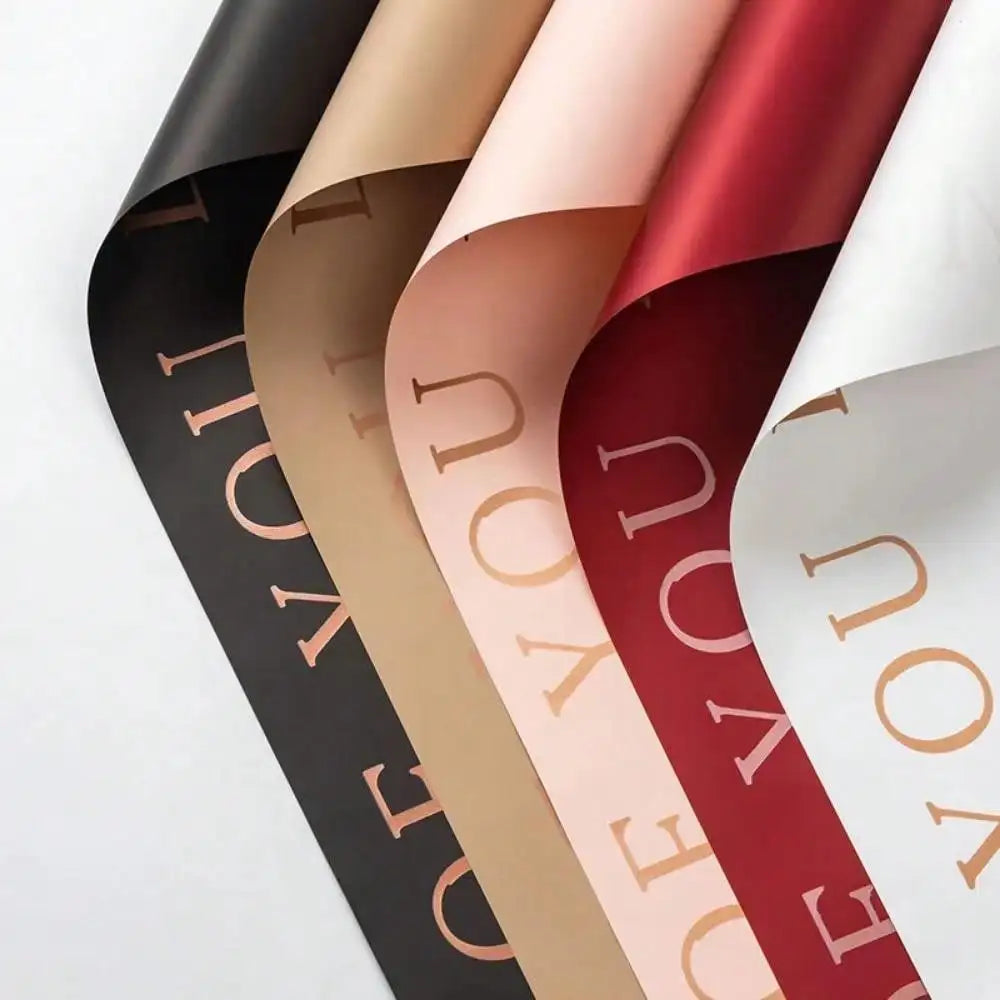 A set of five rolls of waterproof floral wrapping paper in shades of black, beige, pink, and red.
