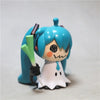 A 7cm PVC collectible statue of Hatsune Miku anime character with blue hair and a white outfit holding a green object.