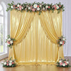 A luxurious gold sequin backdrop curtain decorated with floral greenery and pink roses for photography or events.