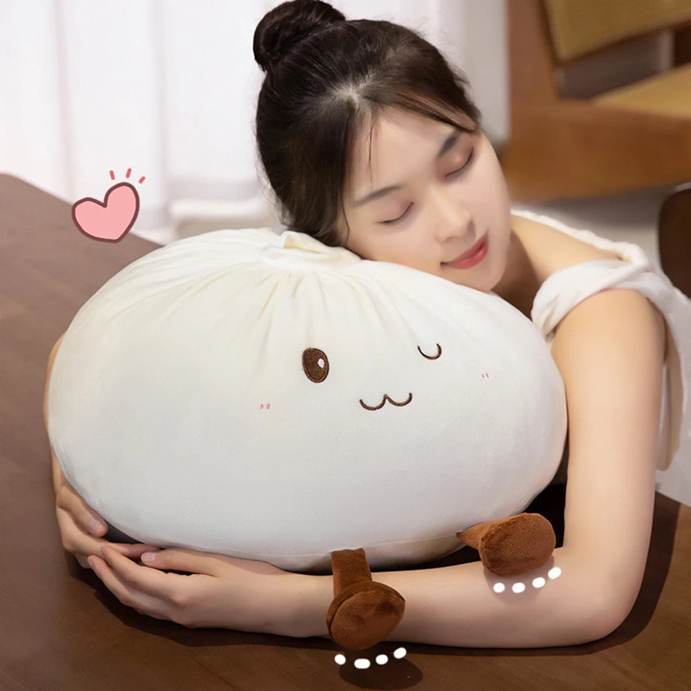 A woman is gently holding a white, round dumpling-shaped plush pillow with cute facial features.