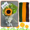 A bouquet of orange sunflowers wrapped in white paper and tied with a sheer ribbon